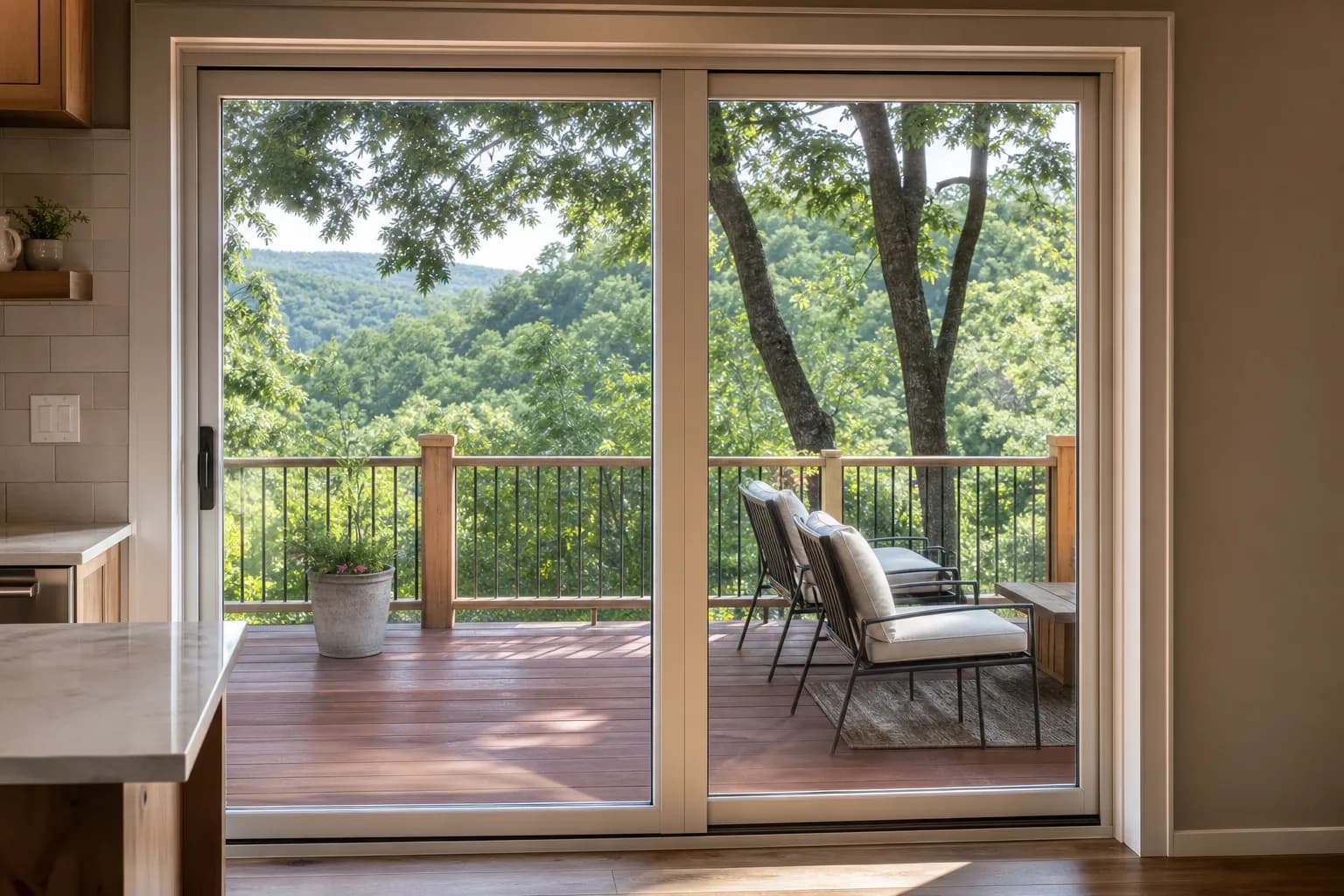 New sliding glass patio door opening onto a wooden deck above a wooded hillside.